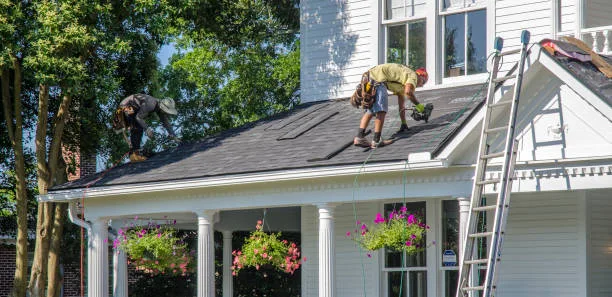 Roof repair contractor inspecting damaged shingles in Annapolis MD