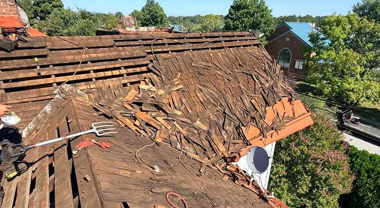 Old roof torn off exposing damaged plank decking on a Laurel, MD home
